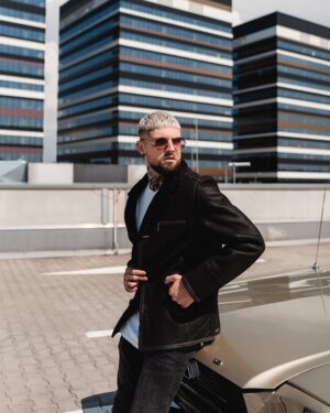 Czarny kożuch męski z kołnierzem, kieszeniami i subtelnymi przeszyciami, idealny na zimowe dni