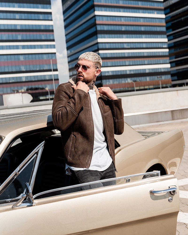 Męski kożuch w brązowym kolorze, z kołnierzem i wyrazistym krojem, idealny na zimowe dni