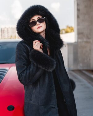 Kożuch damski w kolorze czarnym z futrzanym kapturem i rękawami, elegancki krój z guzikami