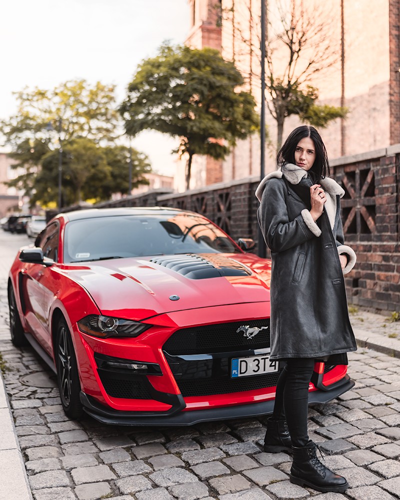 Kożuch damski w szarym kolorze z futrzanym kołnierzem, długim krojem i kieszeniami na bokach