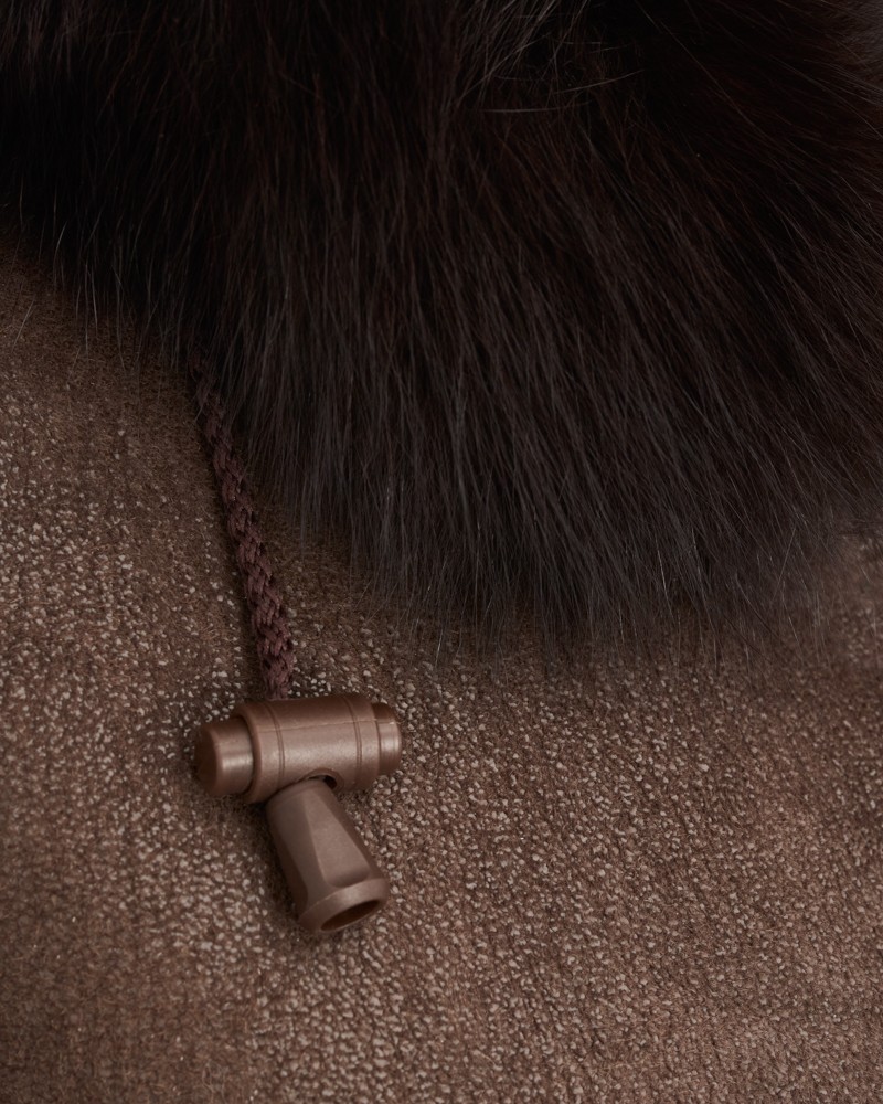 brązowy kożuch damski z futrzanym kołnierzem i ozdobnym zapięciem na sznurku