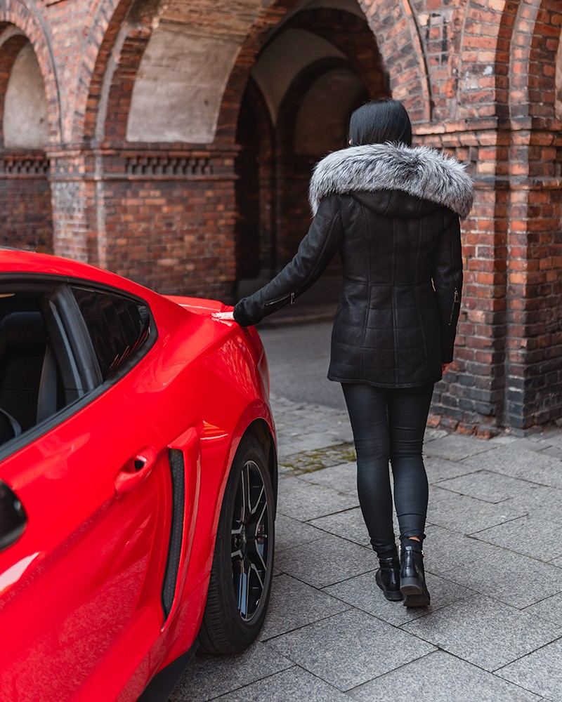 Czarny kożuch damski z futrzanym kołnierzem, idealny na zimowe dni, stylowy i elegancki w miejskim otoczeniu