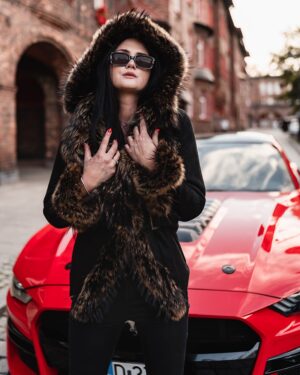 Kożuch damski z dużym futrzanym kapturem, w kolorze czarnym, z eleganckimi detalami i dopasowanym krojem