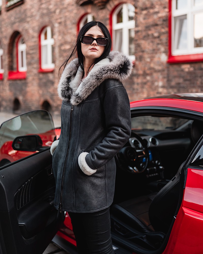 Kożuch damski w kolorze czarnym z futrzanym kapturem i białymi mankietami, idealny na zimowe dni