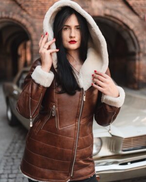 Kożuch damski w kolorze brązowym z futrzanym kapturem i ozdobnymi zamkami w stylu retro