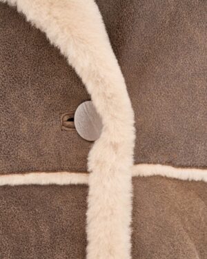 Kożuch damski w kolorze brązowym z miękkim futrem i dużym guzikiem, idealny na zimowe dni