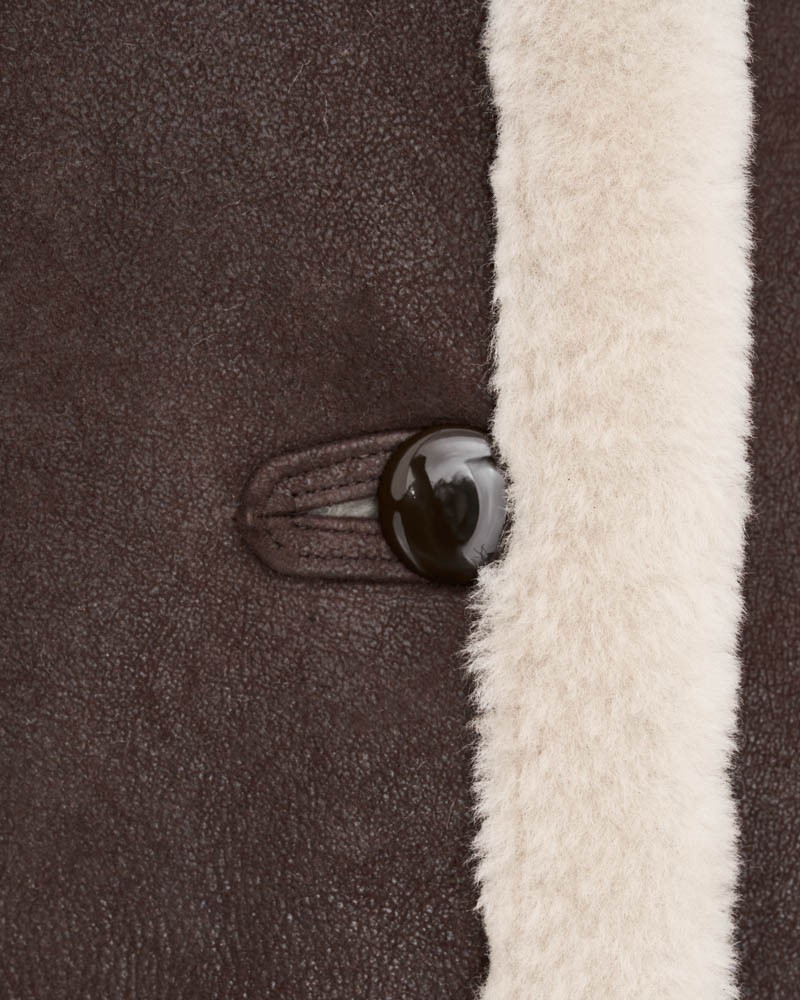 Kożuch damski w ciemnym odcieniu brązu z jasnym futrzanym wykończeniem i dużym guzikiem