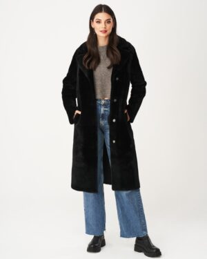 Czarny kożuch damski z dużym kołnierzem, zapinany na guziki, z kieszeniami i długim krojem