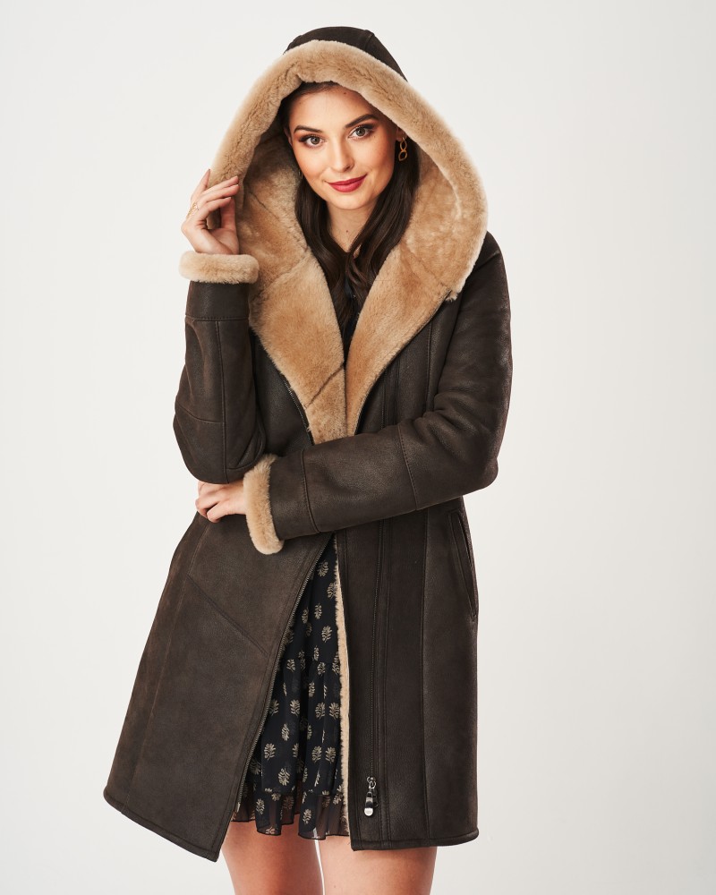 Kożuch damski w ciemnym kolorze z kapturem i futrzanym wykończeniem, zapinany na zamek i z kieszeniami.