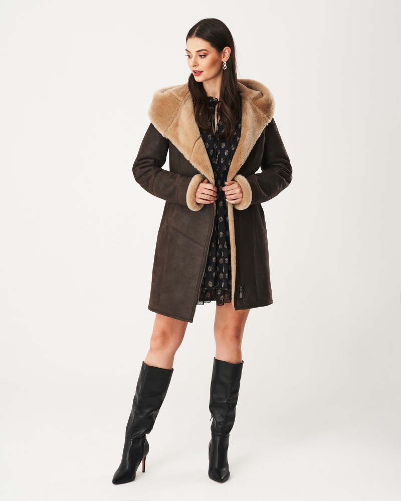 Kożuch damski w ciemnym kolorze z szerokim futrzanym kołnierzem i rękawami, idealny na zimowe dni