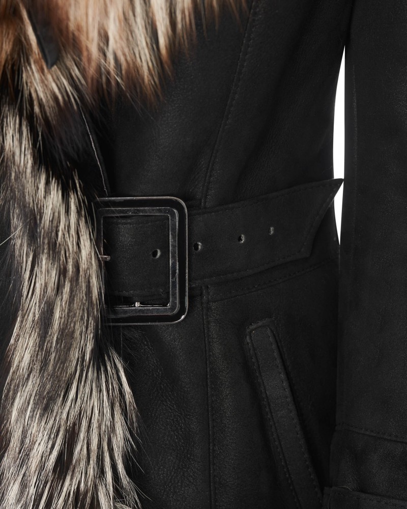 Czarny kożuch damski z futrzanym kołnierzem i paskiem w talii, idealny na zimowe dni