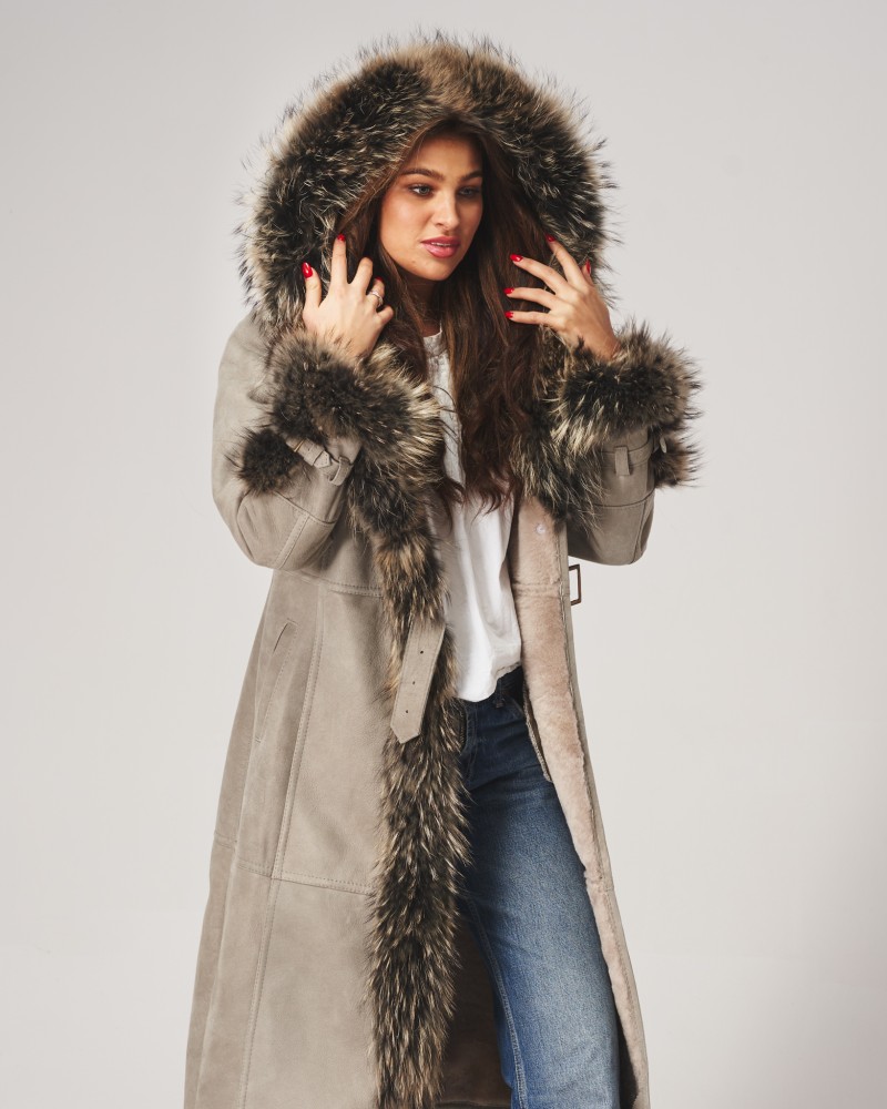 Kożuch damski w jasnym kolorze z futrzanym kapturem i ozdobnymi rękawami, idealny na zimowe dni